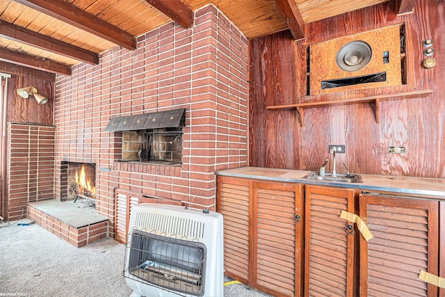 kitchen featuring beamed ceiling, heating unit, and wooden walls