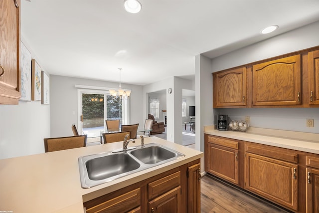 kitchen with dark hardwood / wood-style flooring, sink, decorative light fixtures, and a notable chandelier