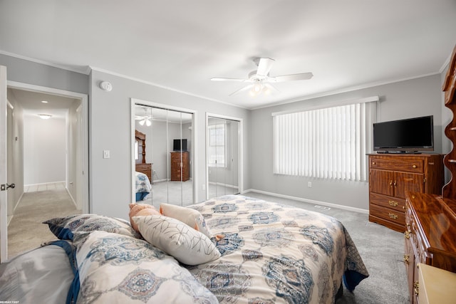 carpeted bedroom featuring crown molding, ceiling fan, and multiple closets