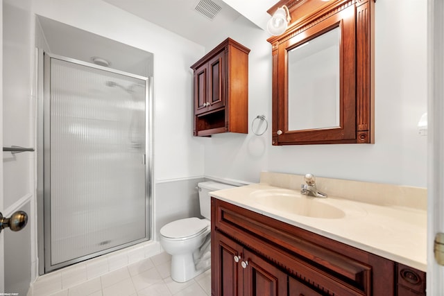 bathroom with vanity, a shower with shower door, tile patterned floors, and toilet