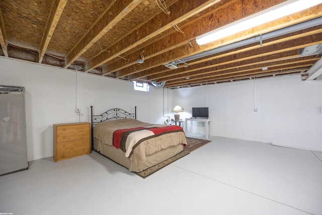 bedroom with concrete flooring and stainless steel refrigerator