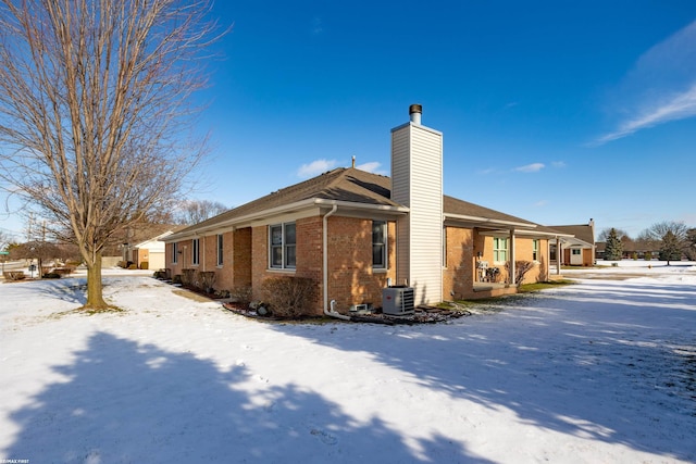 view of snowy exterior featuring central AC unit