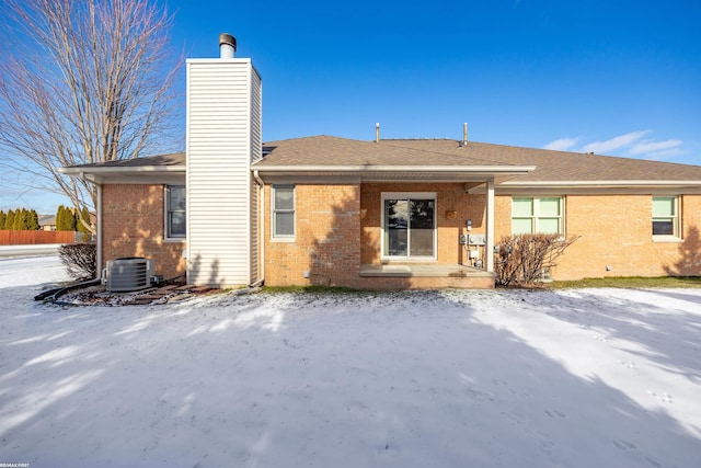 snow covered house featuring central air condition unit