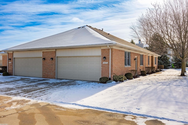 view of snowy exterior featuring a garage