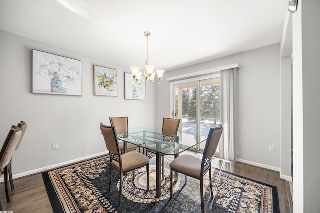 dining area with dark wood-type flooring and a chandelier