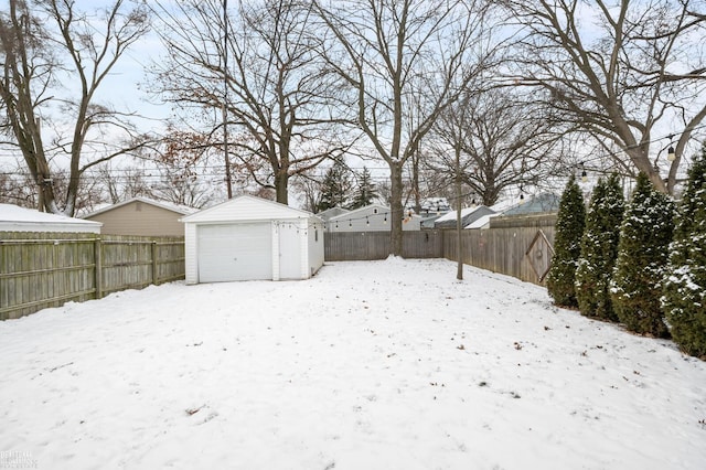 yard covered in snow with a garage and an outdoor structure