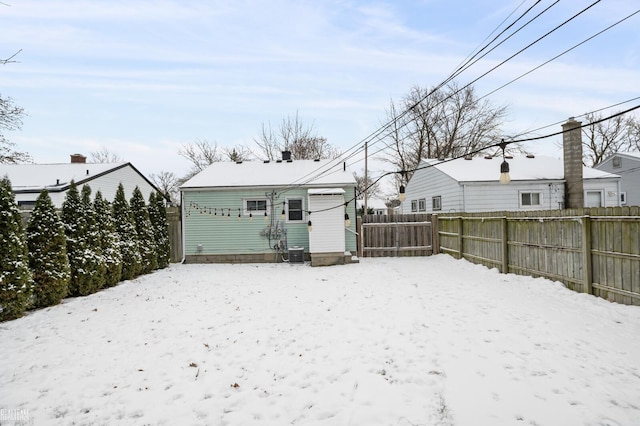 snow covered back of property with central air condition unit