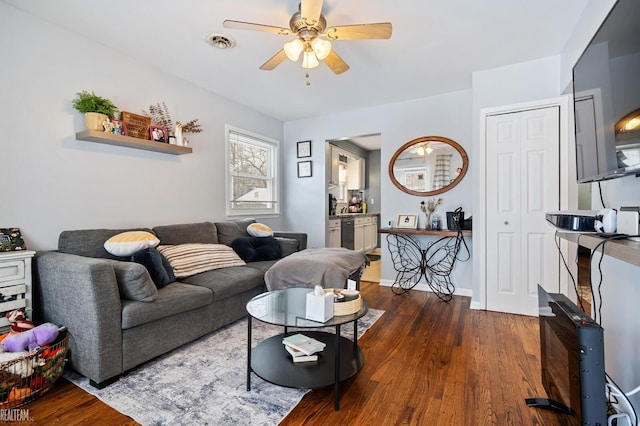 living room featuring ceiling fan and dark hardwood / wood-style floors