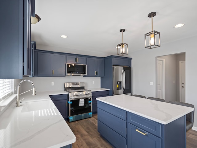 kitchen with pendant lighting, sink, appliances with stainless steel finishes, dark hardwood / wood-style floors, and a center island