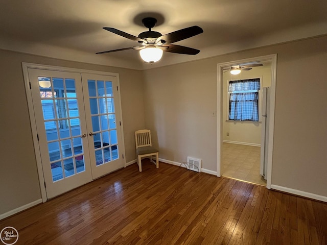 empty room featuring hardwood / wood-style flooring and french doors