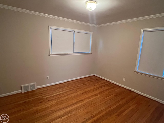 spare room featuring hardwood / wood-style floors and ornamental molding