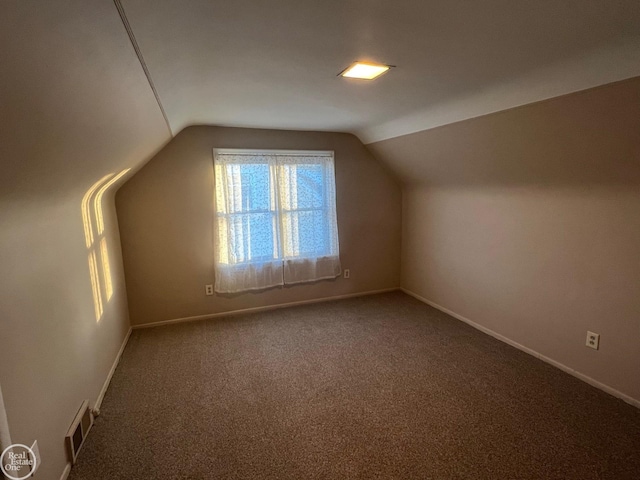 additional living space featuring lofted ceiling and carpet floors