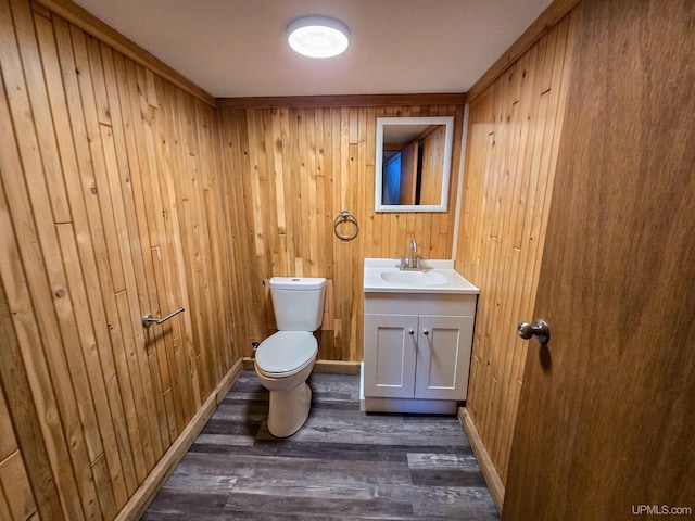 bathroom featuring vanity, wood-type flooring, toilet, and wood walls