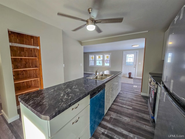 kitchen with appliances with stainless steel finishes, sink, white cabinets, dark hardwood / wood-style flooring, and a center island