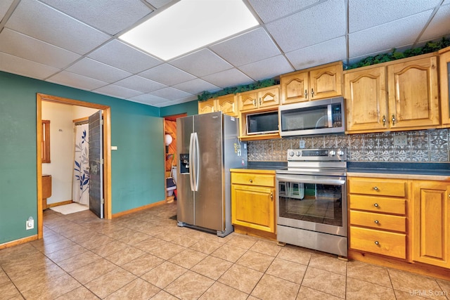 kitchen featuring a drop ceiling, backsplash, and stainless steel appliances