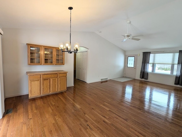 interior space featuring lofted ceiling, dark hardwood / wood-style floors, and ceiling fan with notable chandelier