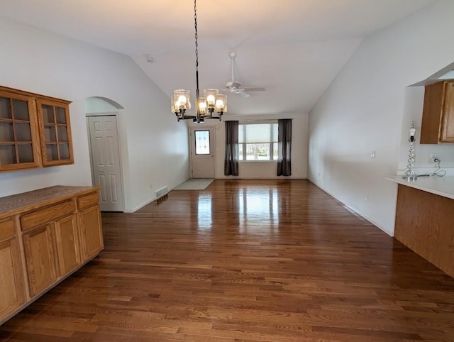 unfurnished dining area with lofted ceiling, dark hardwood / wood-style flooring, and ceiling fan with notable chandelier