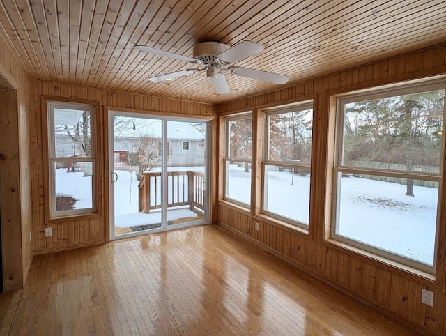 unfurnished sunroom featuring wood ceiling and ceiling fan