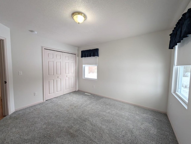 unfurnished bedroom with a closet, a textured ceiling, and carpet