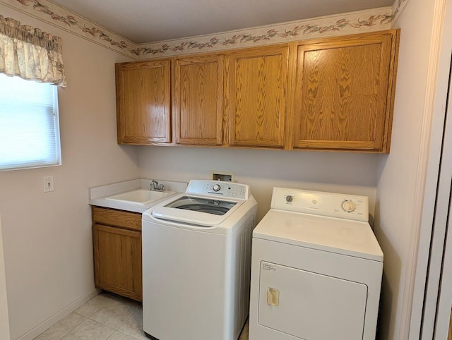 laundry area with cabinets, light tile patterned flooring, sink, and washer and clothes dryer