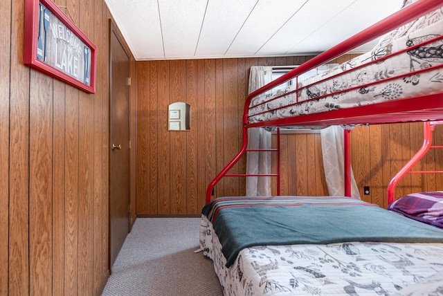 bedroom with carpet and wood walls