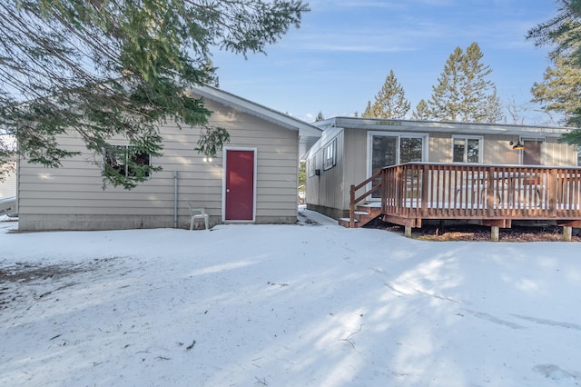 snow covered property with a wooden deck