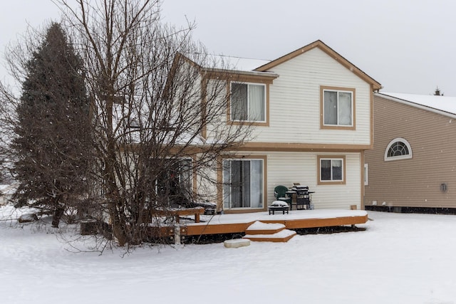 snow covered house featuring a deck