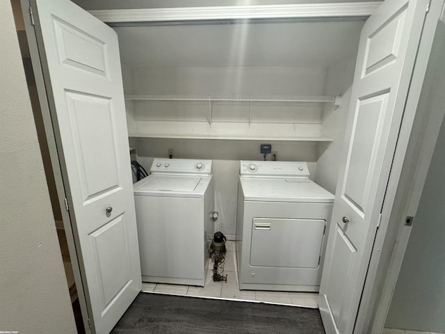 clothes washing area with dark tile patterned floors and washing machine and clothes dryer