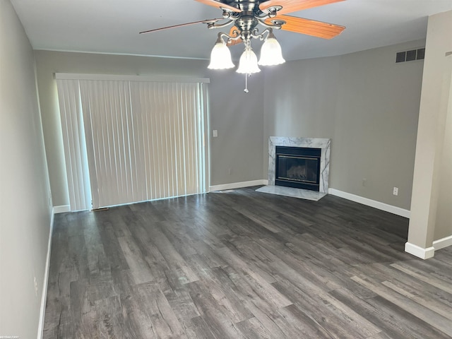 unfurnished living room with dark hardwood / wood-style floors, ceiling fan, and a fireplace