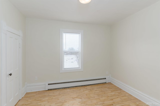 empty room with a baseboard radiator and light hardwood / wood-style floors