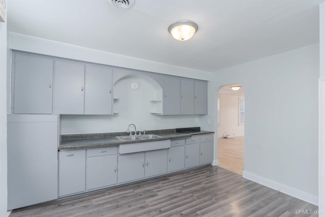 kitchen with gray cabinetry, sink, and light hardwood / wood-style floors