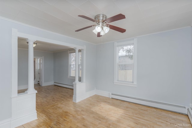 unfurnished room with ornate columns, a baseboard heating unit, and light hardwood / wood-style flooring