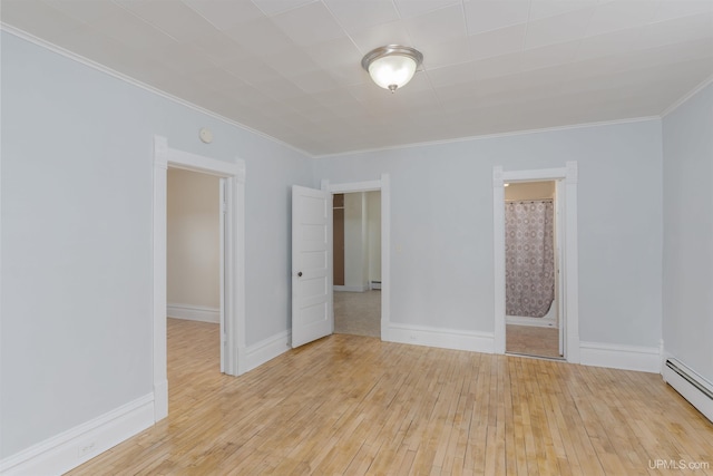 spare room with ornamental molding, light hardwood / wood-style flooring, and a baseboard heating unit