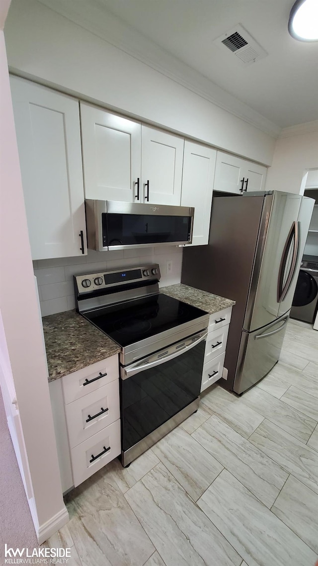 kitchen featuring washer / clothes dryer, crown molding, white cabinets, and appliances with stainless steel finishes