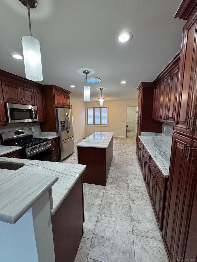 kitchen featuring pendant lighting, sink, stainless steel appliances, tasteful backsplash, and a kitchen island