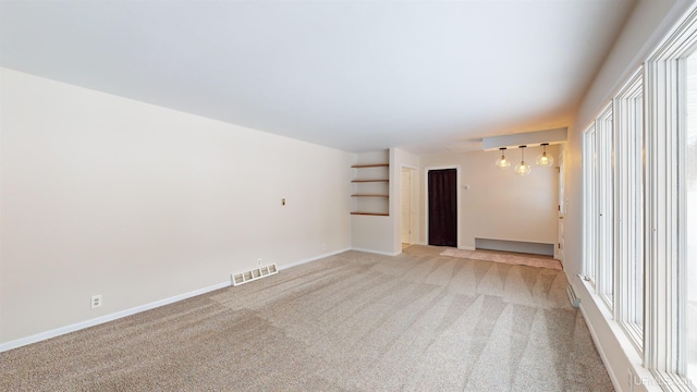 spare room featuring light colored carpet