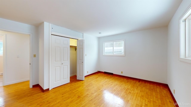 unfurnished bedroom with a closet and light hardwood / wood-style flooring