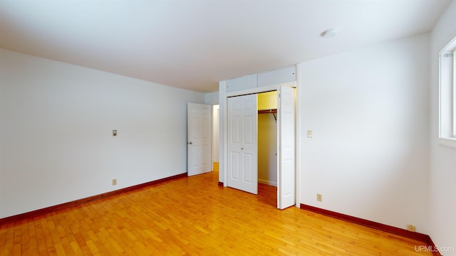 unfurnished bedroom featuring a closet and light wood-type flooring