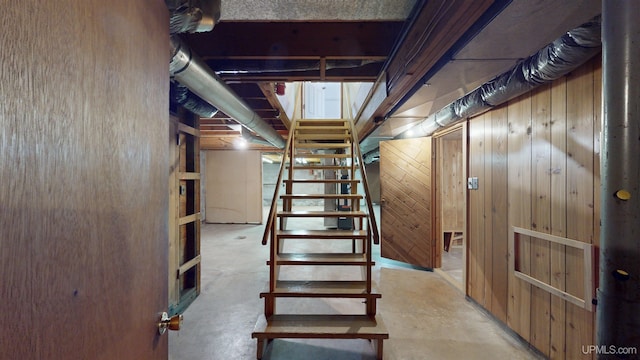 basement featuring wooden walls