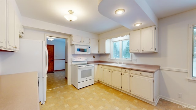 kitchen with sink, white appliances, and white cabinets