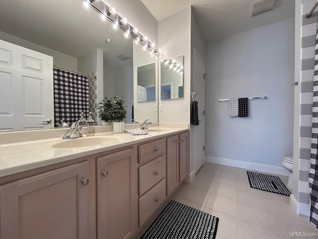 bathroom with tile patterned flooring, vanity, and toilet