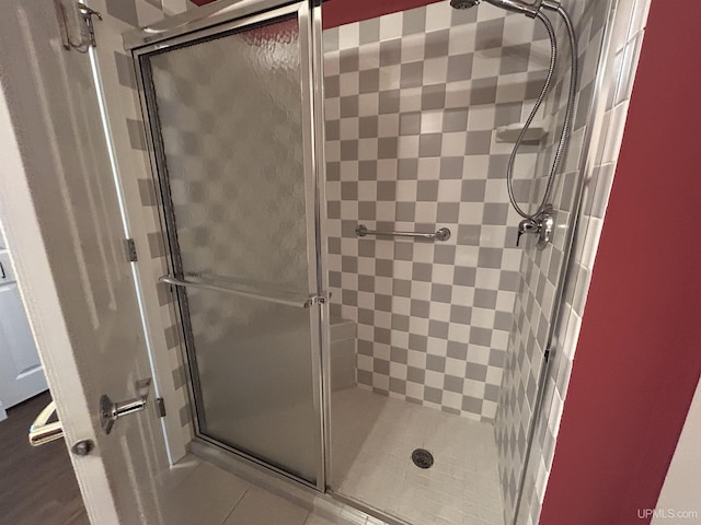 bathroom with an enclosed shower and tile patterned floors