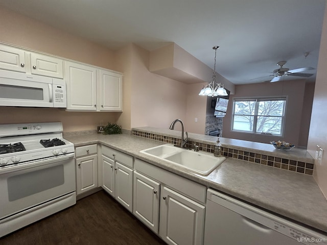 kitchen with white appliances, kitchen peninsula, sink, and white cabinets