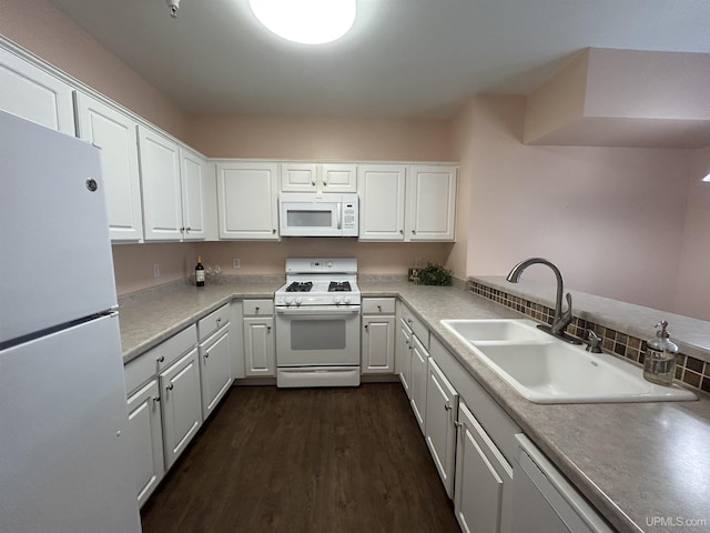 kitchen with sink, white appliances, dark wood-type flooring, and white cabinets