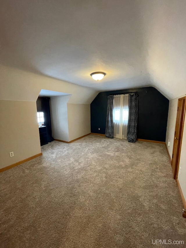 bonus room with carpet flooring and vaulted ceiling