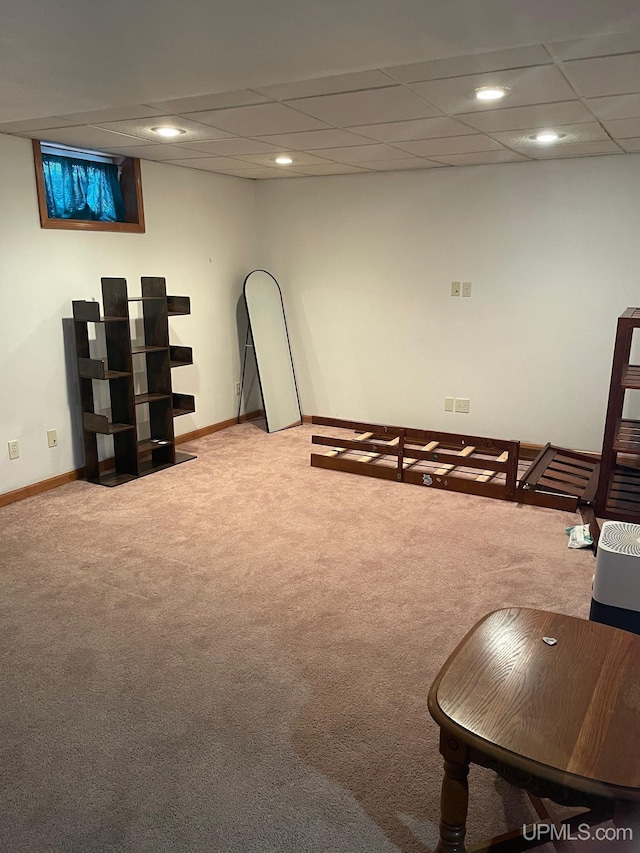 basement with light colored carpet and a drop ceiling