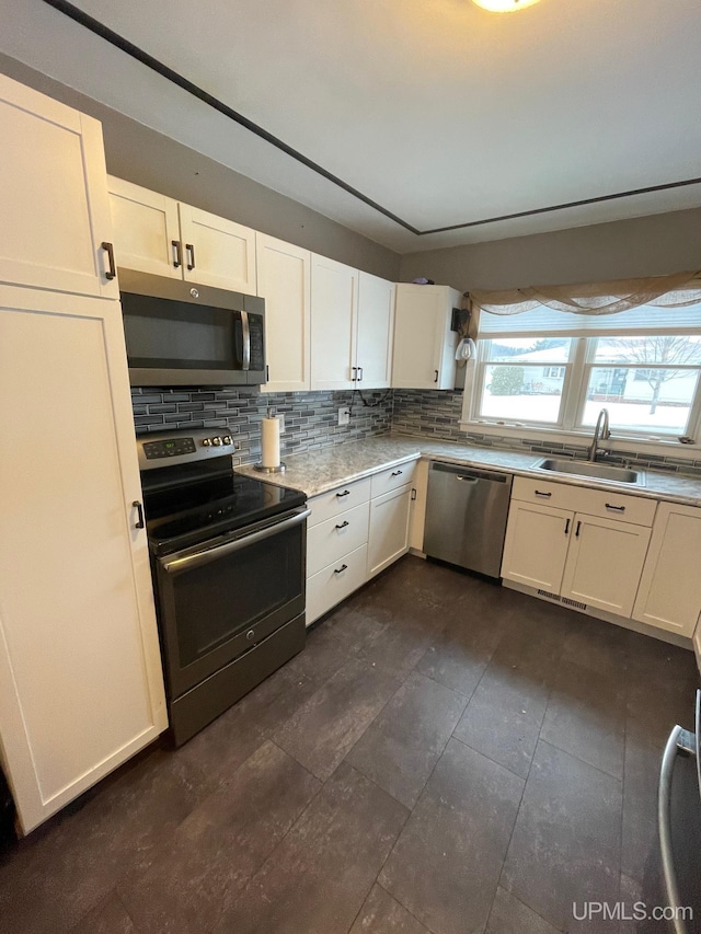 kitchen with tasteful backsplash, stainless steel appliances, sink, and white cabinets