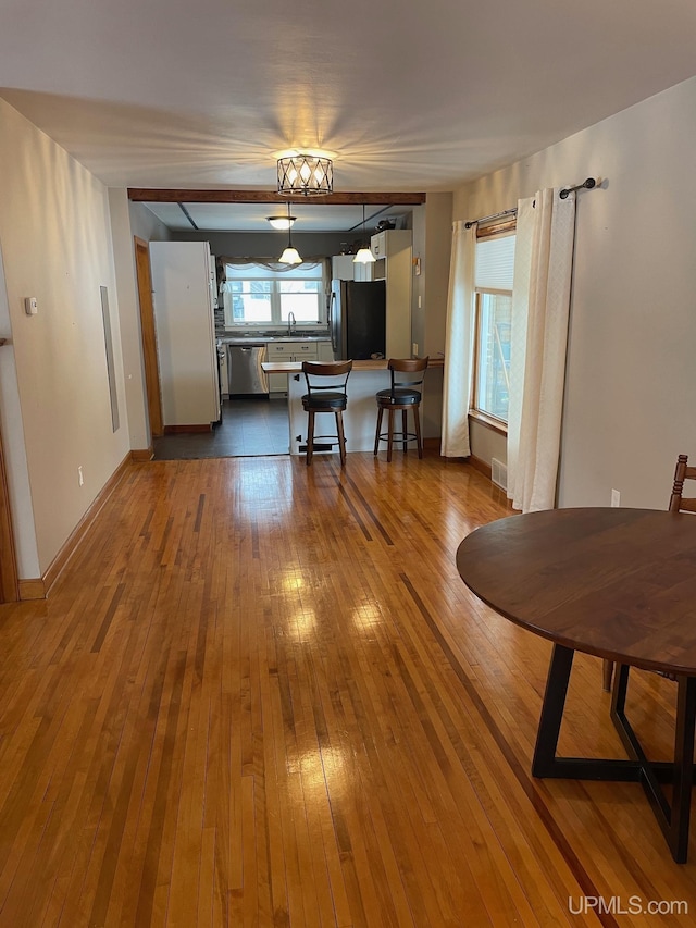 dining room with sink and wood-type flooring