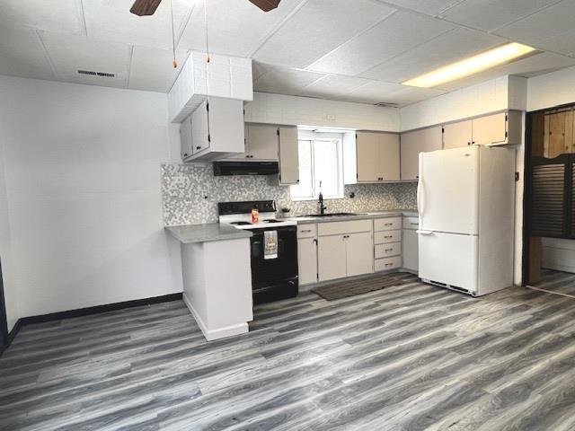 kitchen with range with electric stovetop, white refrigerator, dark hardwood / wood-style flooring, ceiling fan, and backsplash