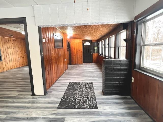 corridor with hardwood / wood-style floors and wooden walls